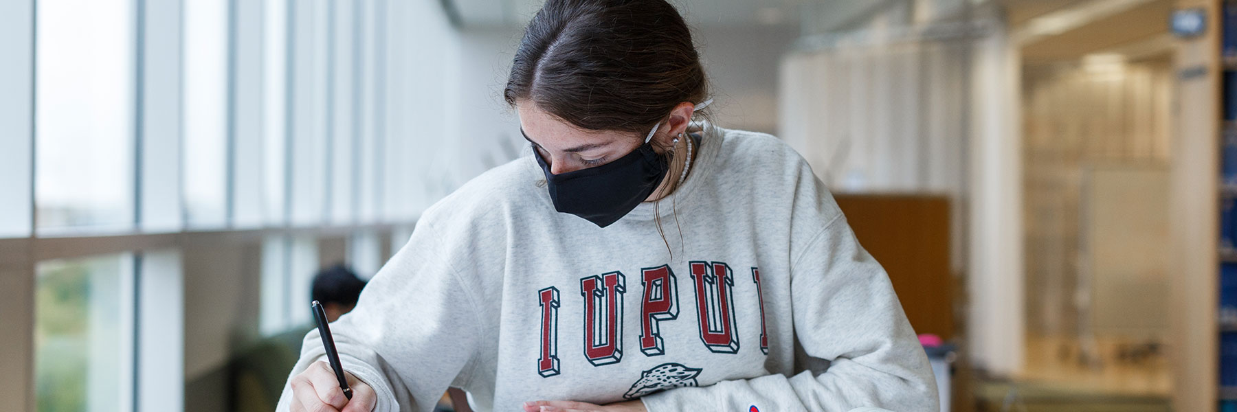 A student working on her homework in the IUPUI library.